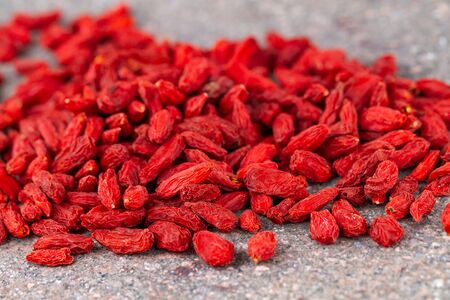 Goji berries scattered on gray stone background. Selective focus.の写真素材