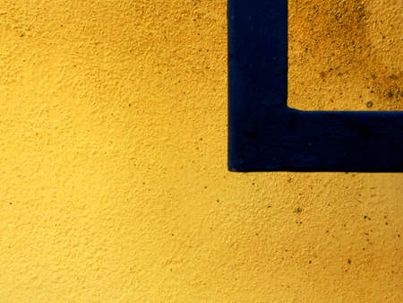 Yellow and Orange speckled wall with a black right angle and space for text.の写真素材