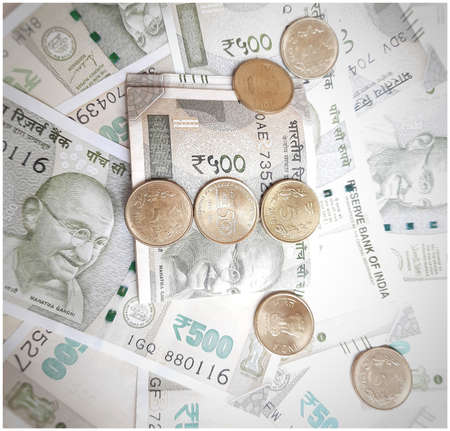 Indian new 500 rupees currency notes spread randomly with 5 rupee coins in white paperの写真素材