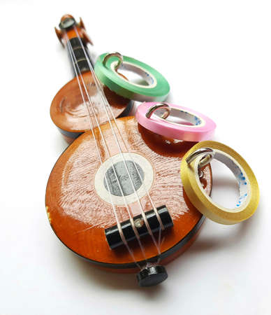 Chennai, India - July 14 2020: Guitar shape Key chain hanger with ribbons placed beautifully in white background for interior home decorationsのeditorial素材