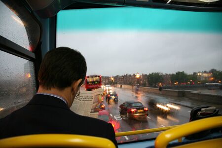 London, UK - August 25, 2010: One bus passenger reads news paper seating on upper deck.  

のeditorial素材