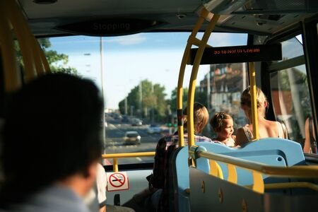 London, UK - July 10, 2010: A little girl seating in front of Dobule Decker Bus, upper deck, with family. のeditorial素材