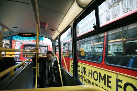 London, UK - November 06, 2010: Interior of London Dobule Decker Bus, one female passenger walking down lower deck.  のeditorial素材
