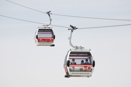 London , UK - May 26, 2013:  Gondolas of the Emirates Air Line cable car, passengers present, opened June 2012, run by TFL, links the Greenwich Peninsula with Royal Dock, 1km, across the River Thames. 
のeditorial素材