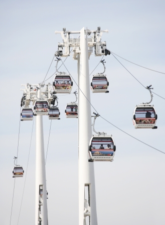 London , UK - May 26, 2013:  Gondolas of the Emirates Air Line cable car, passengers present, opened June 2012, run by TFL, links the Greenwich Peninsula with Royal Dock, 1km, across the River Thames. 
のeditorial素材