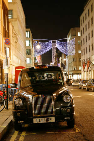 LONDON - November 18, 2011: Taxi in the Bond Street of London. Cabs, Taxis, are the most iconic symbol of London as well as London's Red Double Decker Bus.のeditorial素材