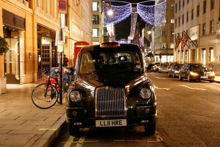 LONDON - November 18, 2011: Taxi in the Bond Street of London. Cabs, Taxis, are the most iconic symbol of London as well as London's Red Double Decker Bus.のeditorial素材