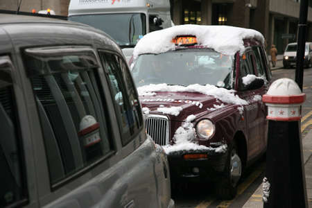 London, UK - December 01, 2010: Snow Covered London Taxi, also called hackney carriage, black cab. Traditionally Taxi cabs are all black in London but now produced in various colors.のeditorial素材