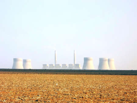 Dying crops during draught with power plant in backgroundの写真素材