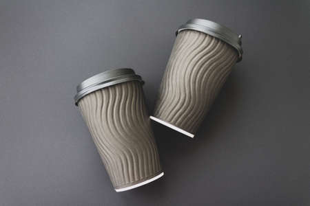 Coffee to go concept. Disposable black cup with spiral texture on a black background. Monochrome. Place for text. Flat lay style. Top viewの写真素材