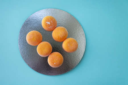 Ice-cream Mochi with mango, traditional japonese rise desert. Orange on pastel blueの写真素材