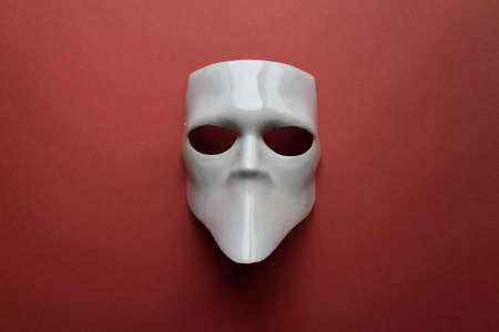 Theatre concept with the white masks on trendy terracotta background. Anonimous, Incognito, Conspiracy concept. Place for text. Flat lay style. Top view.の写真素材