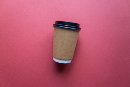 Coffee to go concept. Disposable craft cup with black plastic cover on a trendy classic blue background. Place for text. Flat lay style. Top view.の写真素材