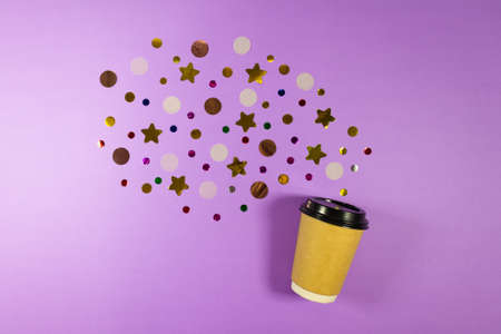 Coffee to go concept. Disposable craft cup with black plastic cover with sparkle glitter confetti on pastel lilac background. Place for text. Flat lay style. Top view.の写真素材