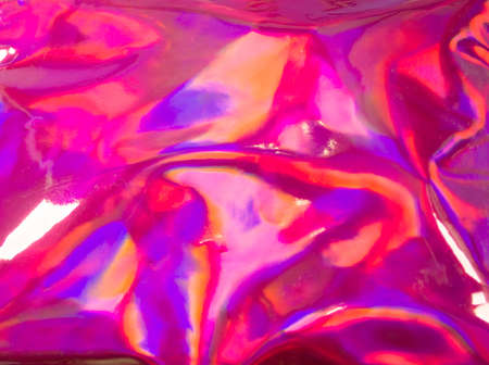 Trendy holographic foil texture background in satorated neon pink violet and orangecolors. Neon colored leather texture backdrop for your design.の写真素材