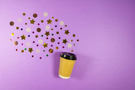 Coffee to go concept. Disposable craft cup with black plastic cover with sparkle glitter confetti on pastel lilac background. Place for text. Flat lay style. Top view.の写真素材