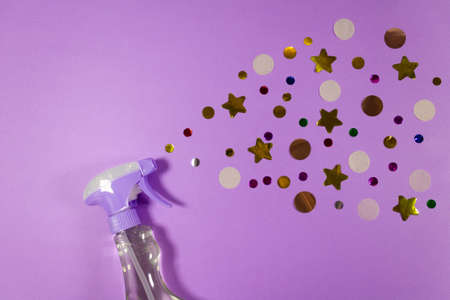 Cleaning agent spray with confetti on pastel lilac background with copy space. Carefree fun cleaning concept. Make your stay in home comfortable and cozy. Top viewの写真素材