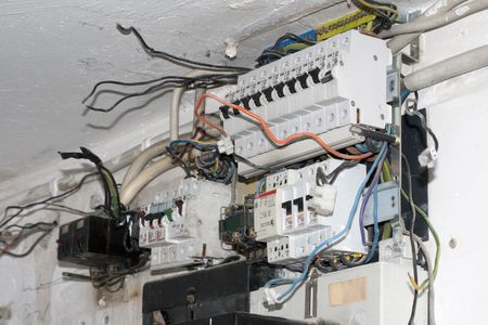 cables hang out at an old control boxの写真素材