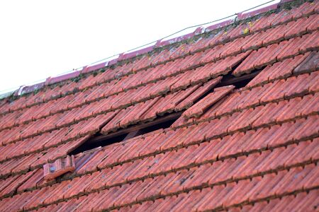 Home roof damage after storm. fall shingles on houseの写真素材