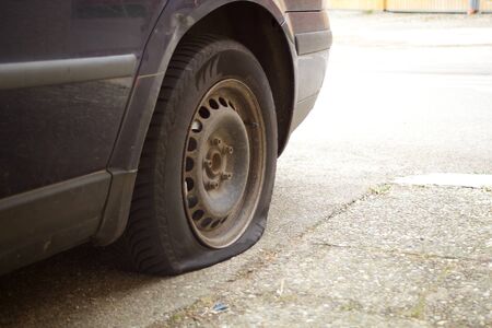 Flat tire, damaged wheel on car lost aerialの写真素材