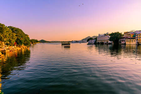 Panoramic sunset view of Udaipur city at Lake Pichola from Ambrai Ghat which is famous tourist vacation destination in Rajasthan, India.の写真素材