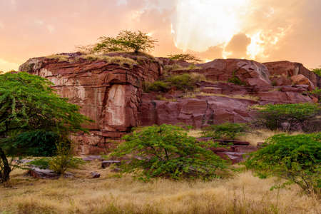 Sandstone forms when layers of sand accumulates by sedimentation are compacted & cemented by precipitation of minerals within pore spaces of sand grains. Red color is imparted by Hematite Iron oxide.の写真素材