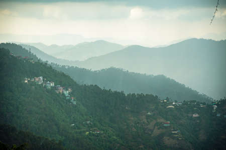 View of Himalayas mountain ranges with visible silhouettes through the fog from Mall Road of Shimla...