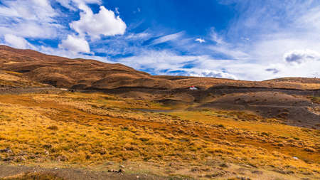 Cold desert barren landscape of Spiti mountain valley with sparse grass vegetation of bunchgrass, located high in rain shadowed region of Himalayas in Himachal Pradesh, India.の写真素材