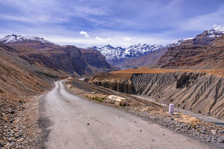 View from hilly mountain road  travelling to Chandrataal Lake through gully eroded geological landform prominent in cold desert of Spiti valley due to barren steep slopes and weak geological mud rocksの写真素材