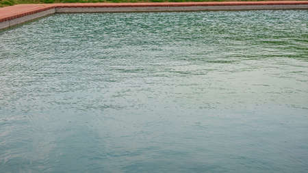 A large, manmade pond  with turquoise water in India.の写真素材