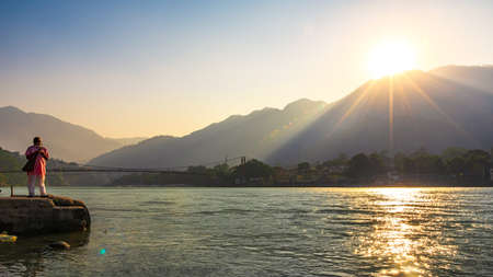Spectacular panoramic cityscape of Rishikesh during sunrise, the yoga capital of World located in foothills Himalayas along banks of river Ganga or Ganges in Uttarakhand state of India.の写真素材