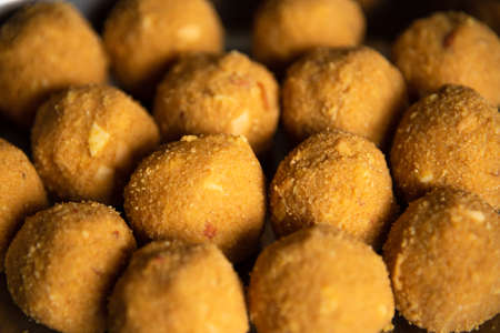 Closeup selective focus of homemade besan Laddoo or roasted gram flour mixed with desi Ghee and...