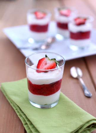 Strawberry and mascarpone parfait in glasses with spoons and napkinの写真素材