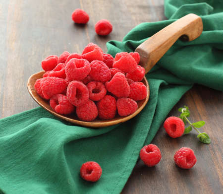 Fresh raspberries in a big wooden spoonの写真素材