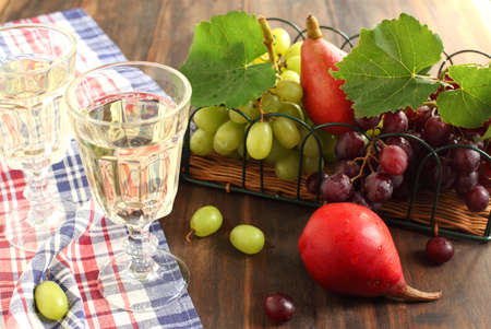 Glasses of white wine, grapes and pears の写真素材