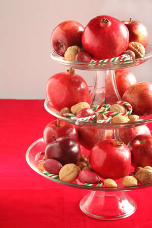 Apples, pomegranates, nuts and candy canes in a vaseの写真素材
