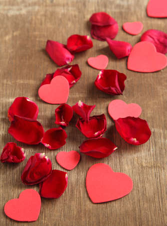 Rose petals and heart shaped on wooden background の写真素材