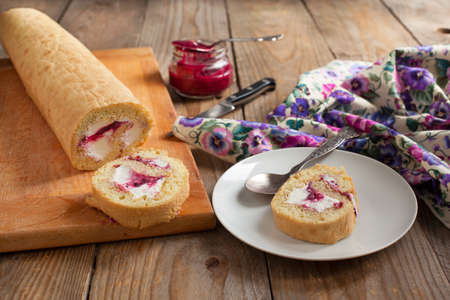 Homemade swiss roll with whipped cream and black currant jamの写真素材