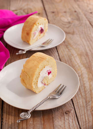 Homemade swiss roll with whipped cream and black currant jamの写真素材