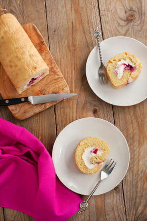 Homemade swiss roll with whipped cream and black currant jamの写真素材