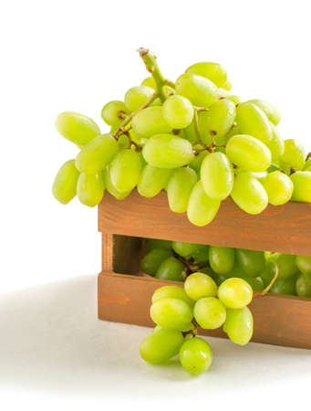 Fresh grapes in wooden box isolated on white backgroundの写真素材