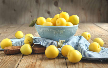 Fresh yellow plums on wooden tableの写真素材