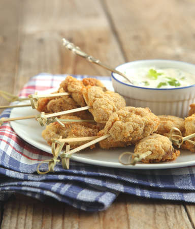 Fried cornmeal-crusted chicken bites with yogurt herb dressingの写真素材
