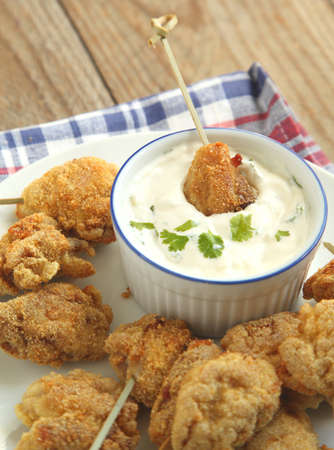 Fried cornmeal-crusted chicken bites with yogurt herb dressingの写真素材
