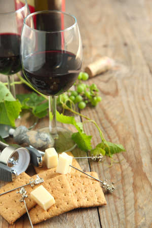 Glasses of red wine with cheese, crackers and grapeの写真素材