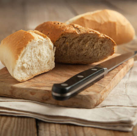 Whole grain bread and white bread on wooden chopping board  Selective focusの写真素材