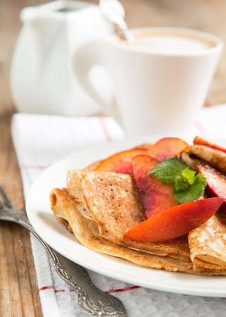 Crepes with fresh peaches for breakfastの写真素材