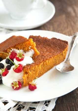 Slices of carrot cake with whipped cream and berryの写真素材
