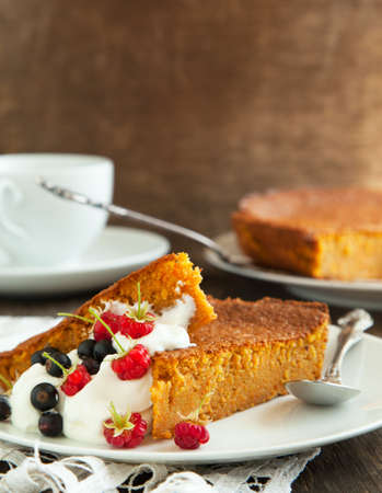 Slices of carrot cake with whipped cream and berryの写真素材