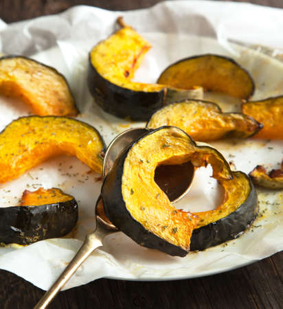 Baked pumpkin slices with herbs and olive oilの写真素材
